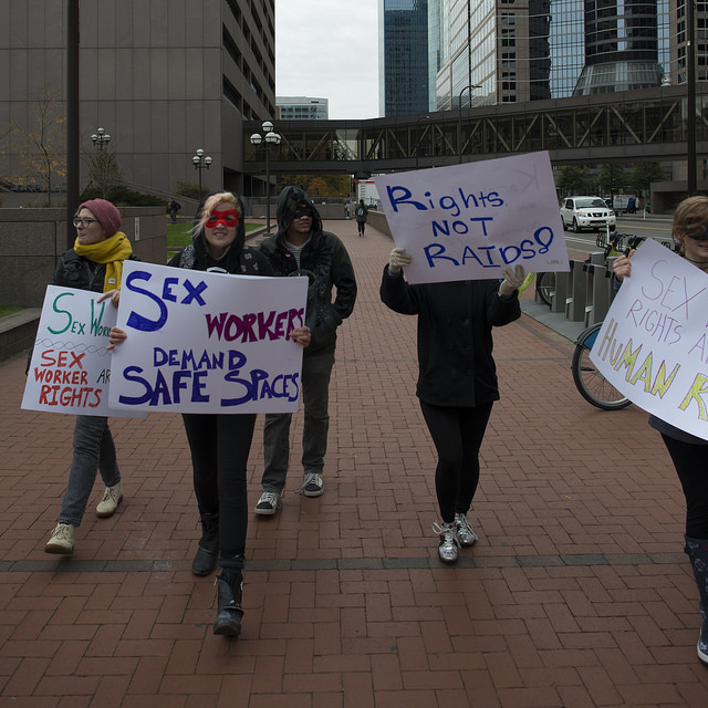 Sex workers' protest in the streets of New York. They are holding banners demanding their rights.