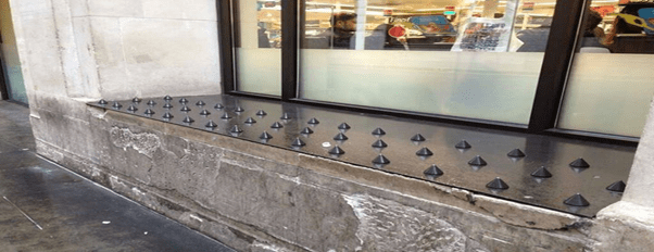 Anti-homeless spikes on a window ledge outside a shop